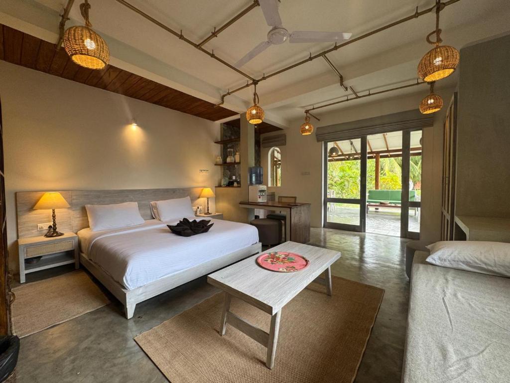 a bedroom with a white bed and a table at Kitesurfing Lanka in Kalpitiya