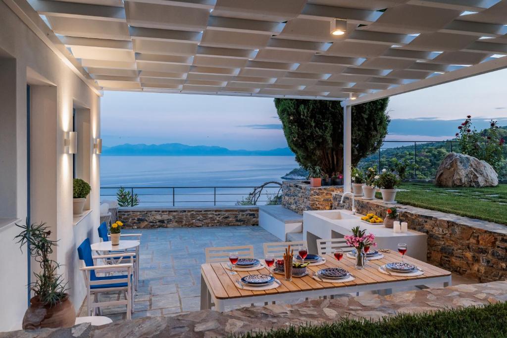 a patio with a table and chairs under a pergola at Villa Aless in Skopelos Town