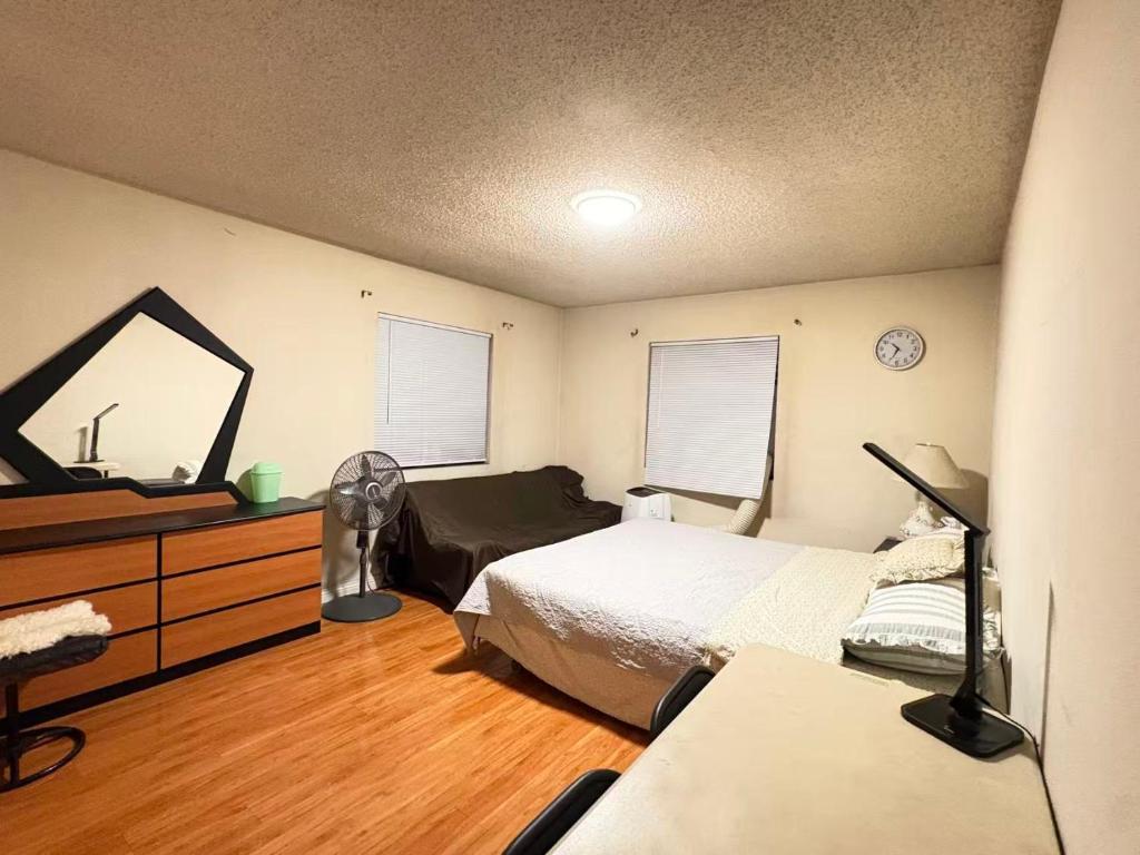 a bedroom with a bed and a dresser and a mirror at Palm Cabin in San Gabriel