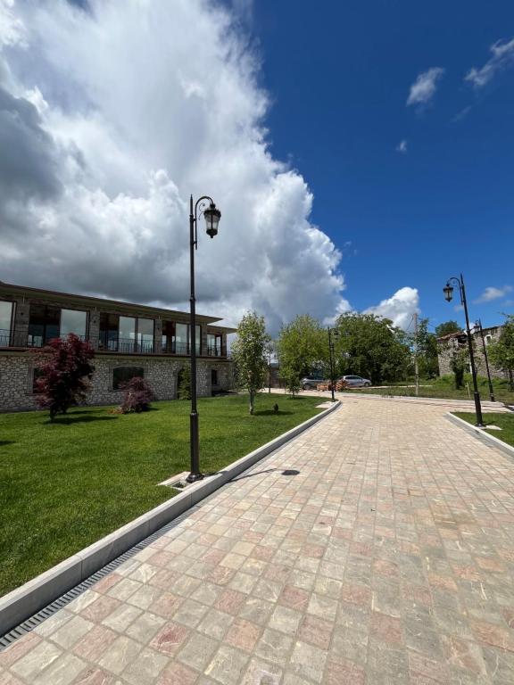 a brick road with a street light in front of a building at Gurra resort in Klos