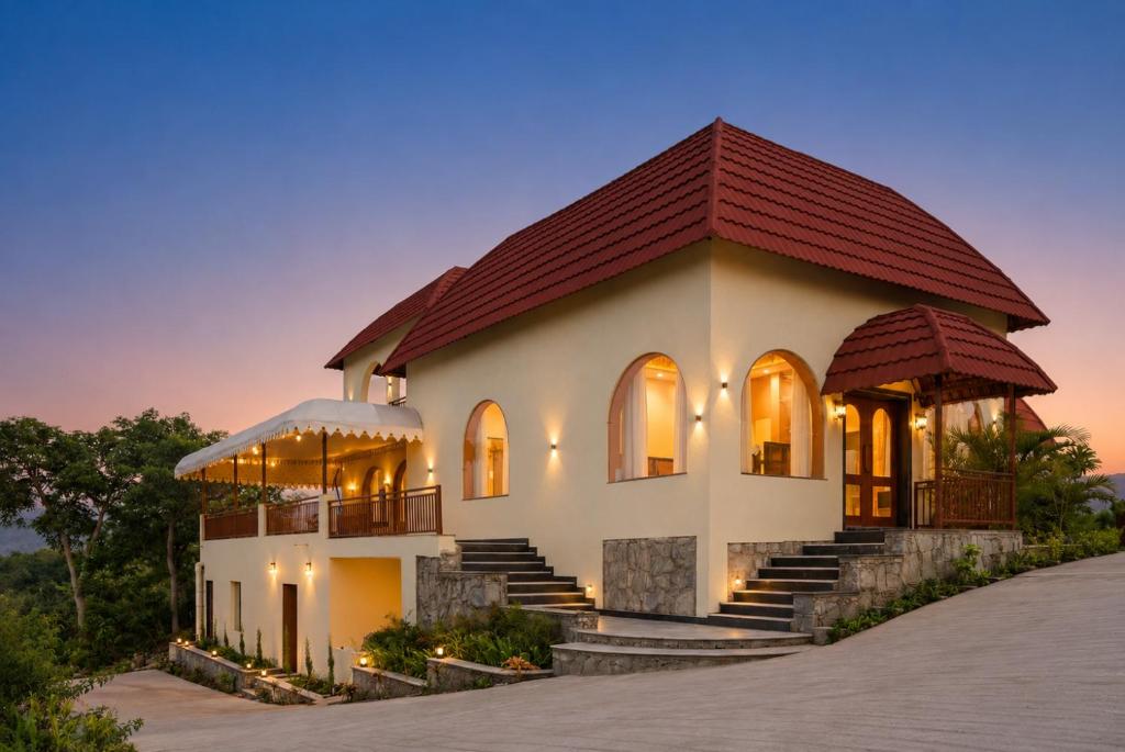 a house with a red roof at Aamba Bagh Resort Kumbhalgarh in Kumbhalgarh