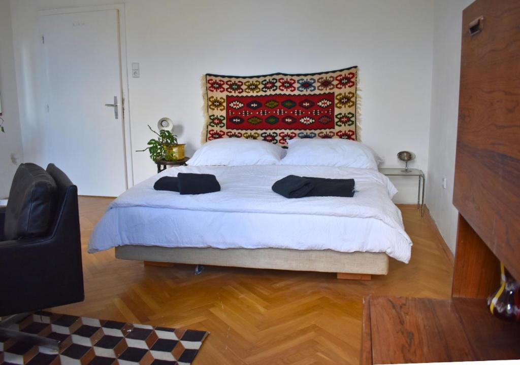 a bedroom with a large white bed with a rug on it at vintage house - LGBTQ & female friendly in Vienna
