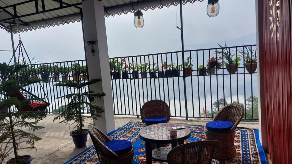 a patio with a table and chairs and a balcony at Nini's Homestay, Kalimpong in Pedong