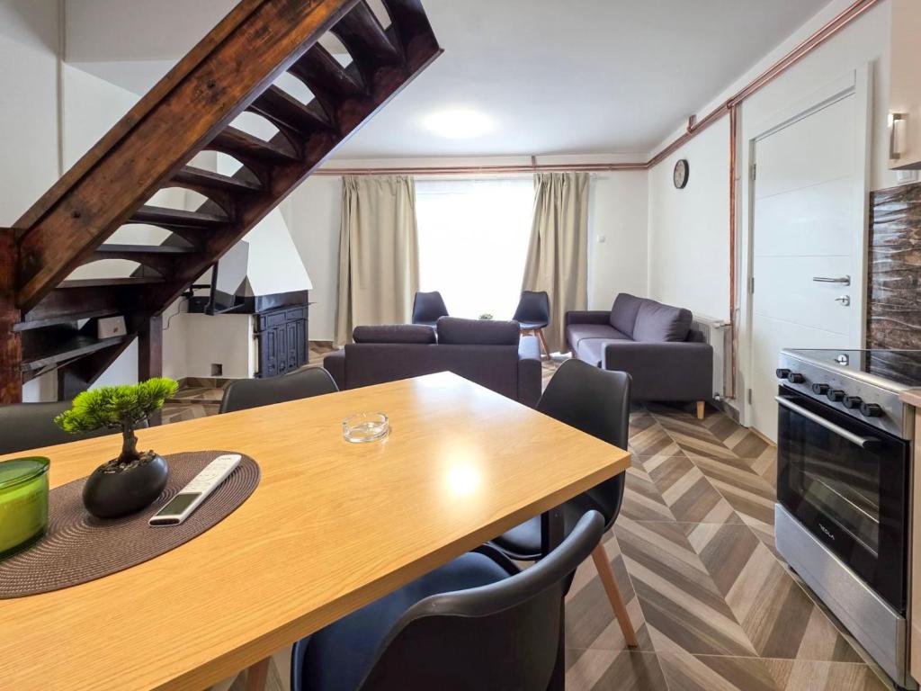 a kitchen and living room with a wooden table and chairs at Vila Vidovic Drina in Bajina Bašta