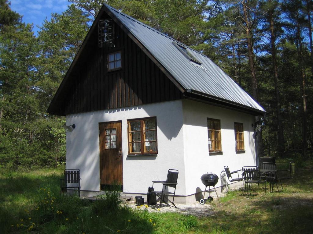 a small white house with a black roof at Fårö stonehouse in Fårö