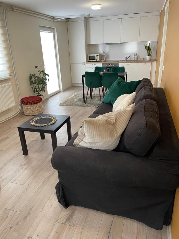 a living room with a black couch and a table at Tamme maja - Oak Tree House with big terrace and balcony in Tapa