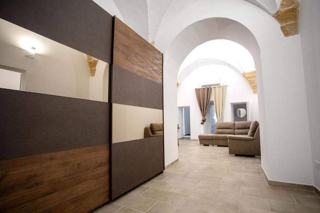 a hallway with a living room with a couch and a door at Palazzo '800 Cementine in Leverano