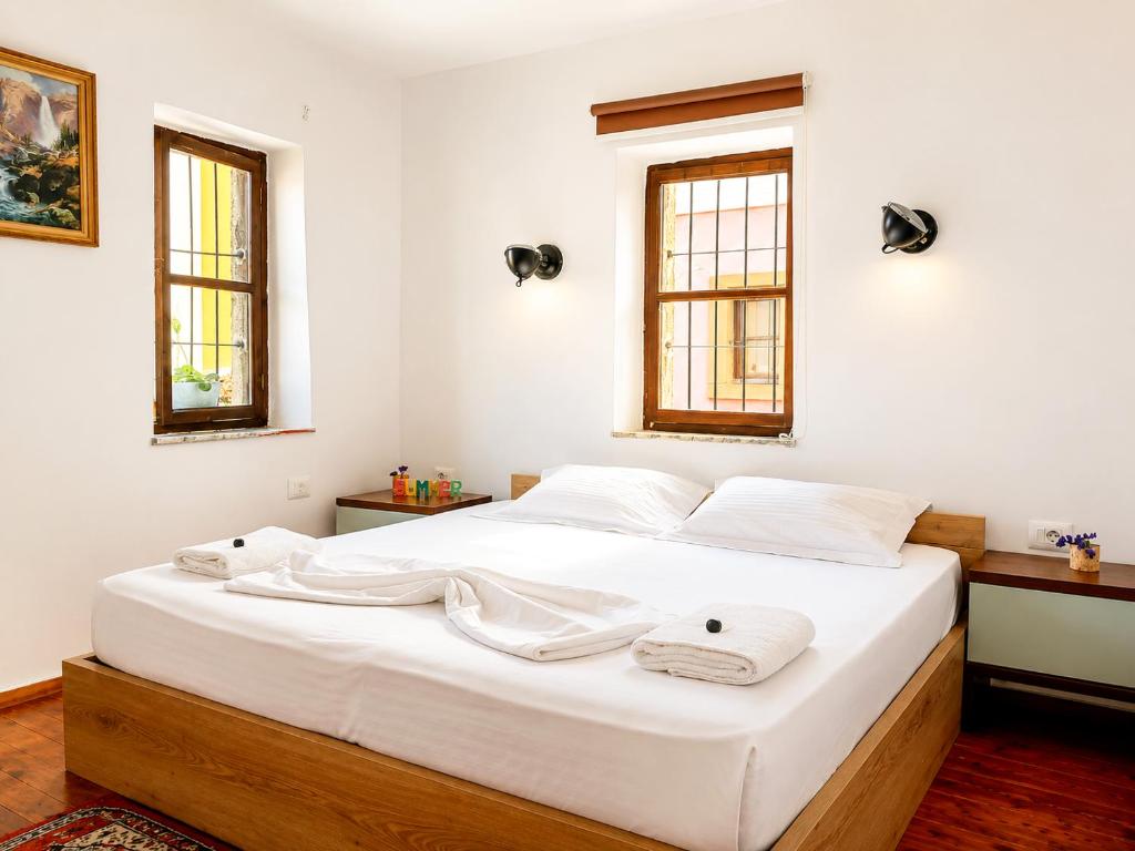 a bedroom with a large white bed with towels on it at Rise And Shine Rooms Korca in Korçë