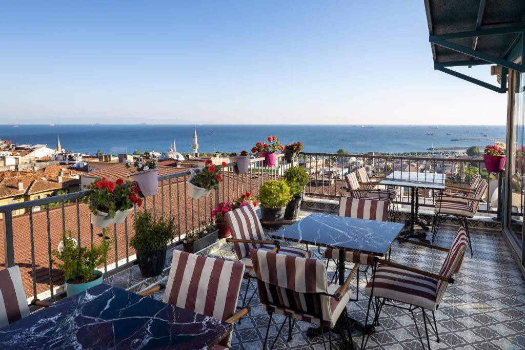 a balcony with tables and chairs and a view of the ocean at Sultanahmet Nu Hotel in Istanbul
