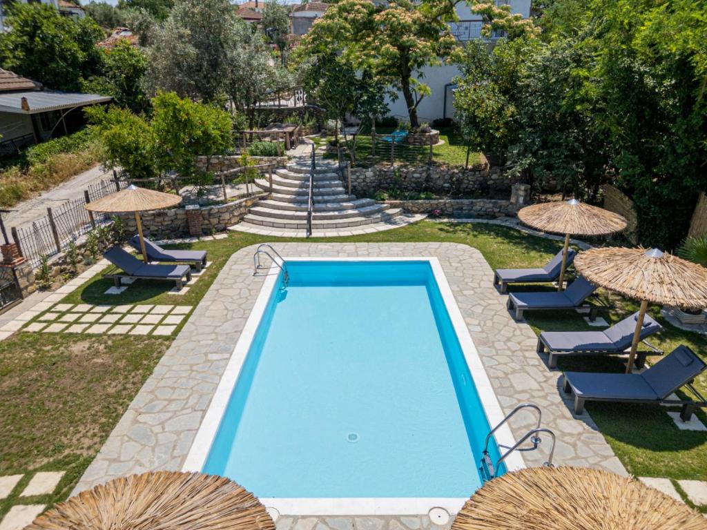 an empty swimming pool with chairs and umbrellas at Vila Petro in Evkarpía