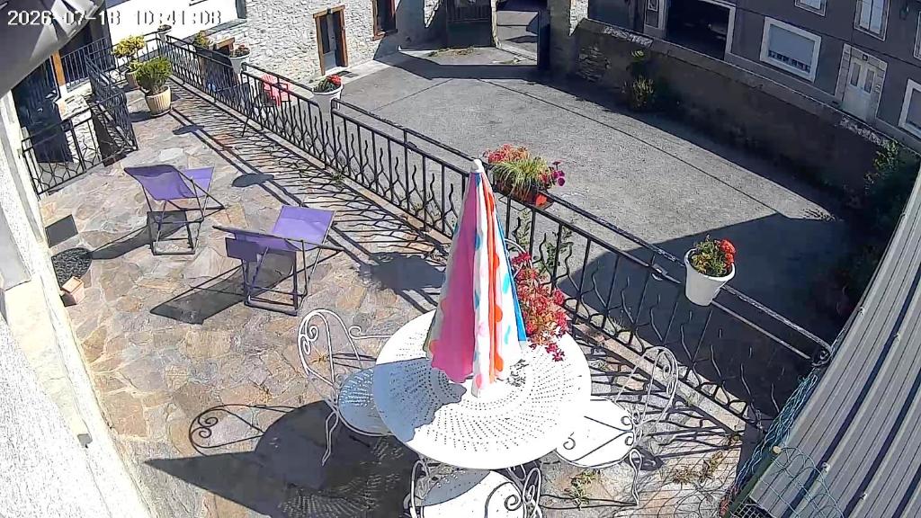 a patio with a table with a umbrella and chairs at Maison individuelle a Arreau in Arreau