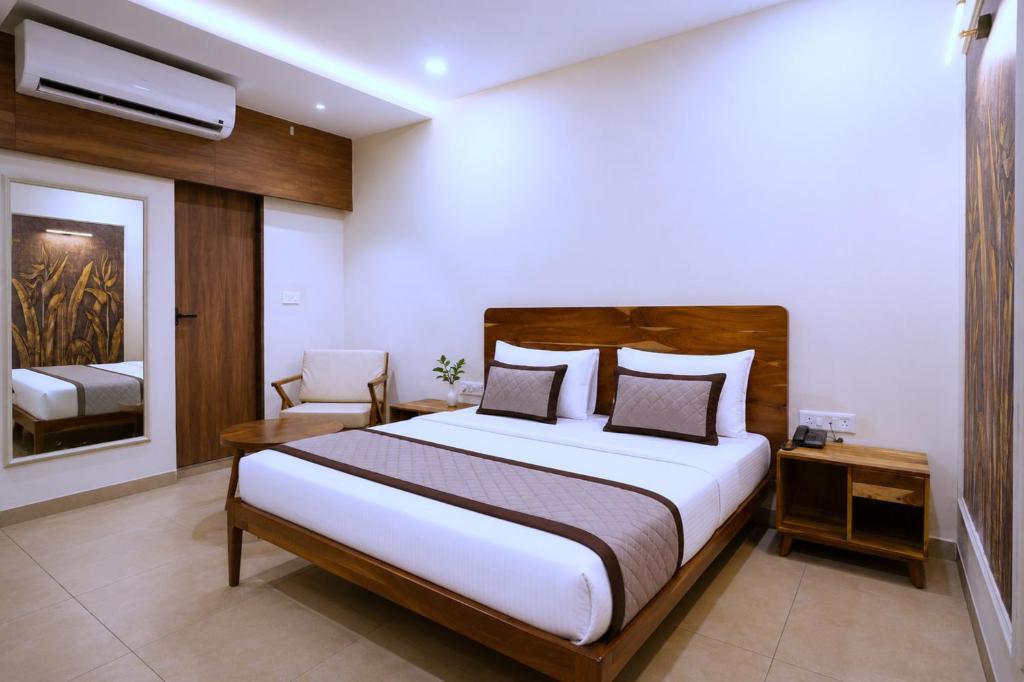a bedroom with a large bed and a chair at Raahi Home Stay Near Iskcon temple & Pushpa Mission Hospital in Ujjain