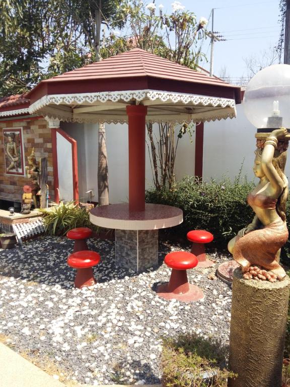 einen Pavillon mit einem Tisch und einigen roten Pilzen in der Unterkunft Rerawadi Resort in Khun Han