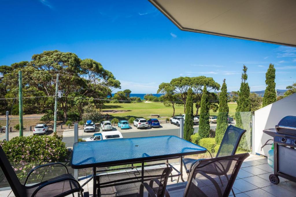 a patio with a ping pong table and chairs at Seachange Apartments Merimbula in Merimbula