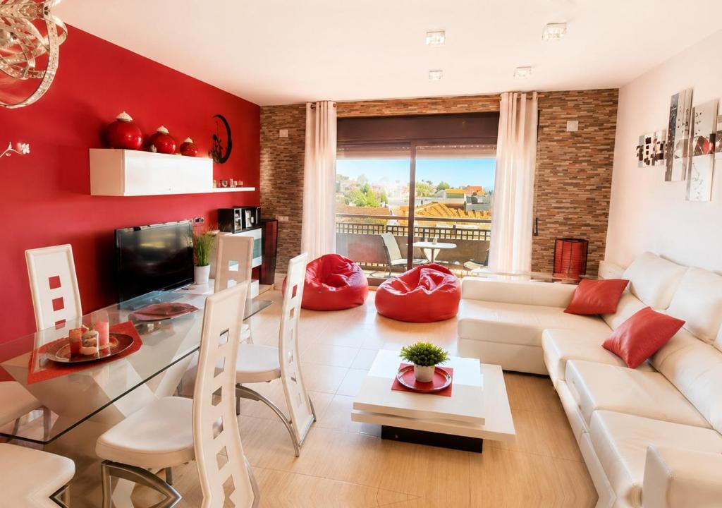 a living room with a white couch and red walls at Casa Roda de Bará & Spa in Roda de Bará