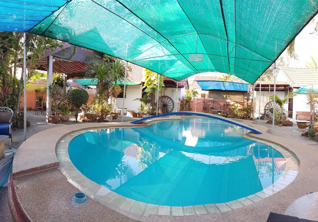 uma grande piscina com um guarda-chuva azul sobre ela em Bamboo Garden em Ban Non Sung