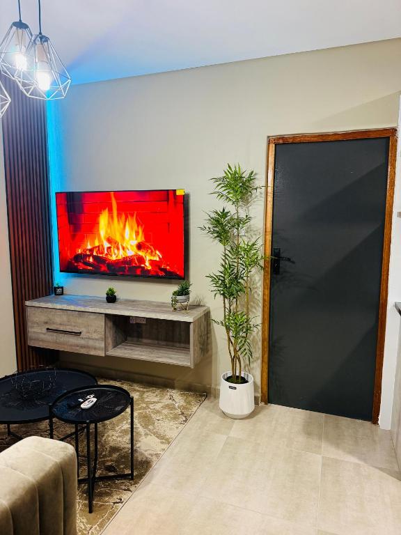 a living room with a fireplace with a tv on the wall at No75 Stays in Tlokweng