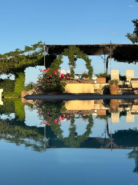 a reflection of a bridge with flowers in the water at Agrisalotto in Cortona