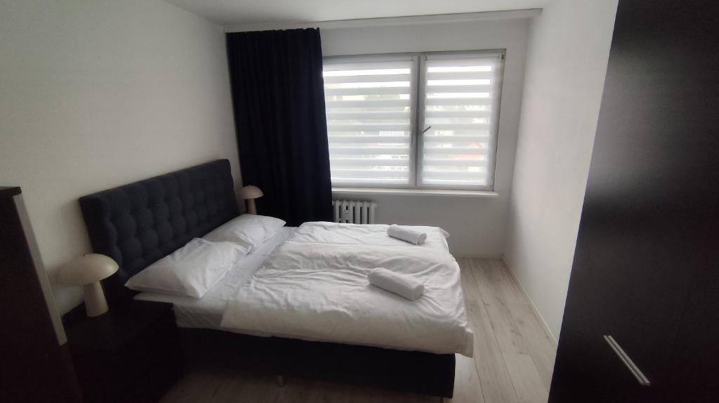 a small bedroom with a bed and a window at Jura Horizon in Myszków