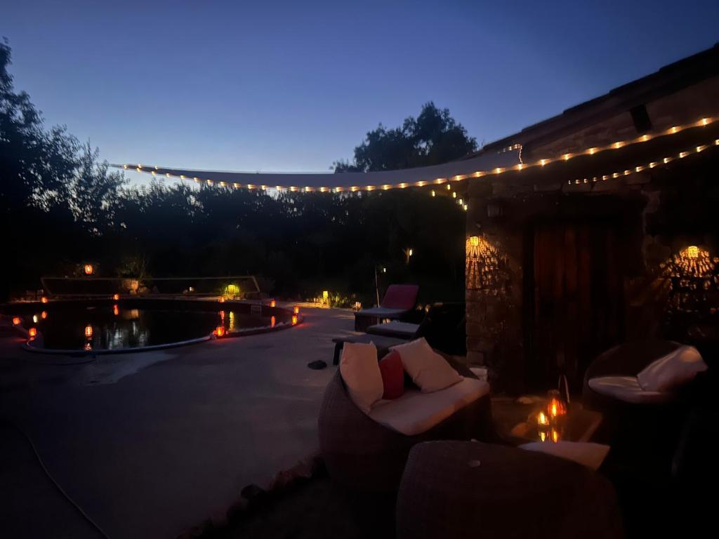 a patio with couches and lights at night at Maison en pierre in Saint-Cyr