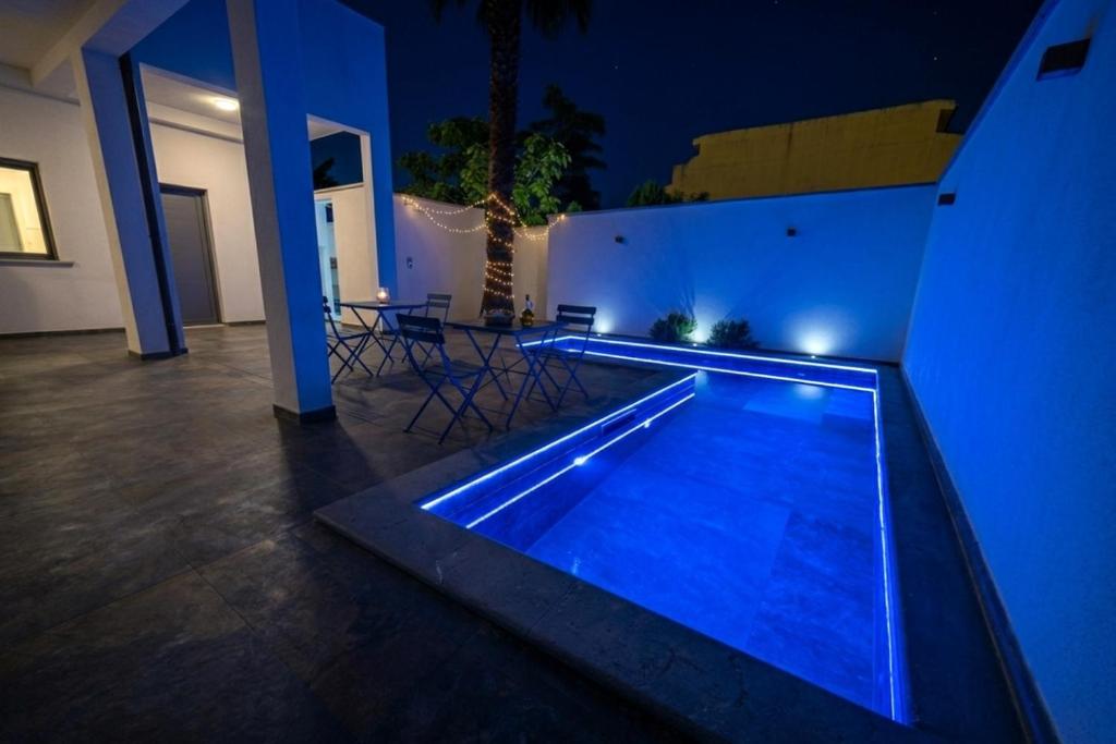 a swimming pool in a house at night at SiRiuS rooms & charme in Villasimius