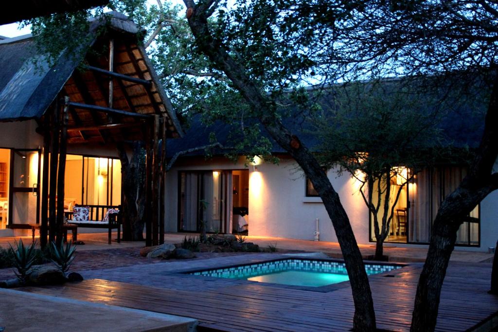 a house with a swimming pool in front of a house at Switsongo Boutique B&B in Hoedspruit