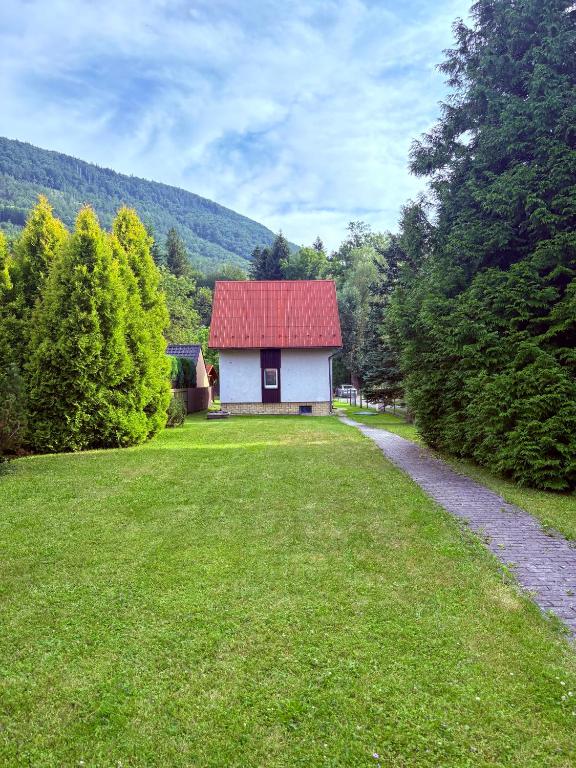 a small house with a red roof in a yard at Chalupa v Beskydech in Trojanovice