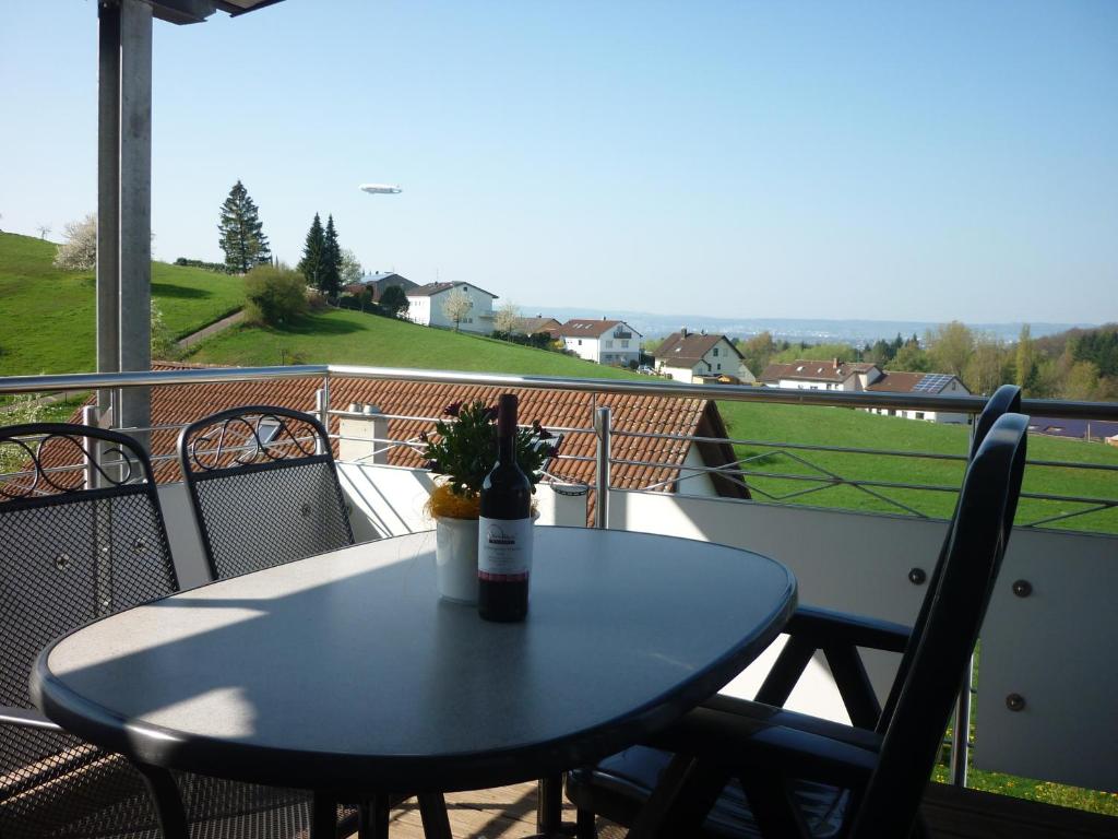 a bottle of wine sitting on a table on a balcony at Weingut Bernhard in Daisendorf