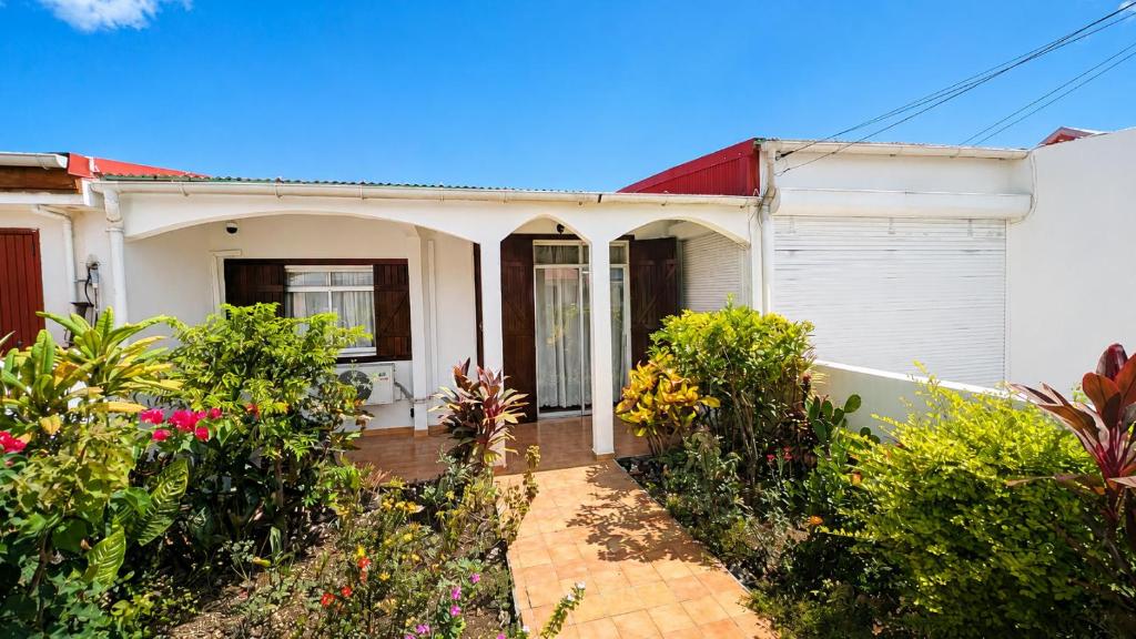 a white house with a red roof at La Casa Créole, spa, 3 ch, 2 sdb, centre de la Guadeloupe in Les Abymes