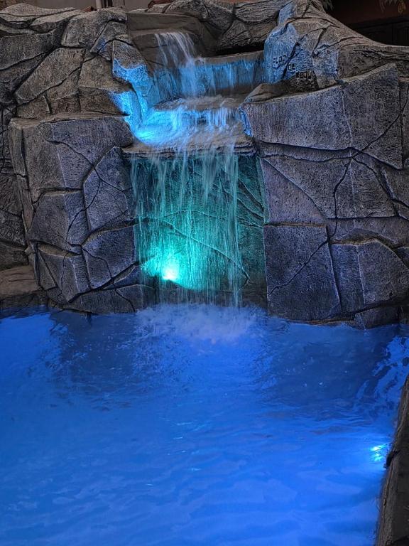 a waterfall in a pool with blue water at Pousada Flor de Pequi in Serra do Cipo