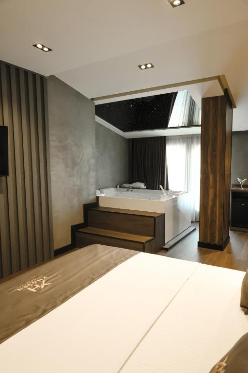 a bedroom with a bed and a desk and a window at Xhasen Hotel & Café in Tirana