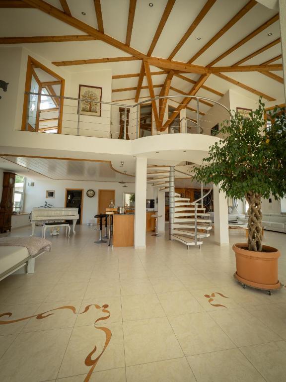 a large living room with a tree in the middle at 280m2 Luxus Loft Atrium-X 60m2 Terrasse in Rorbas