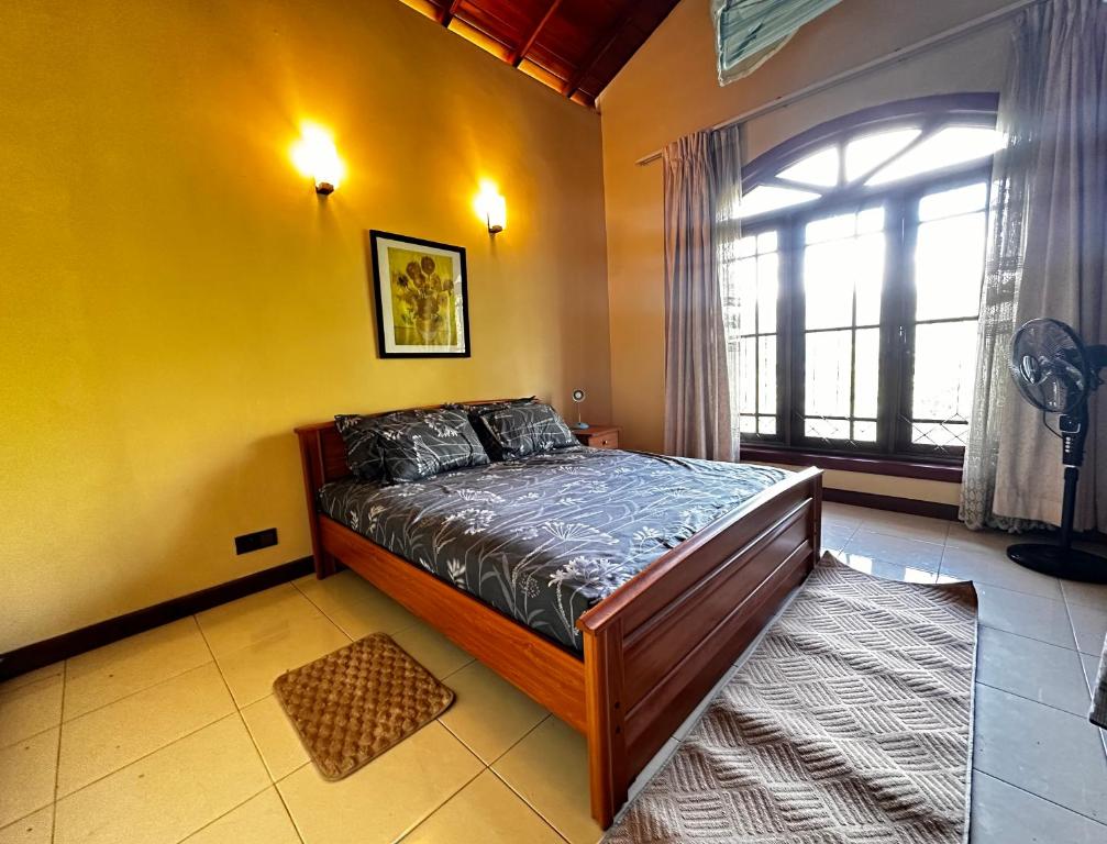 a bedroom with a bed and a large window at Johannes Nest in Gampola