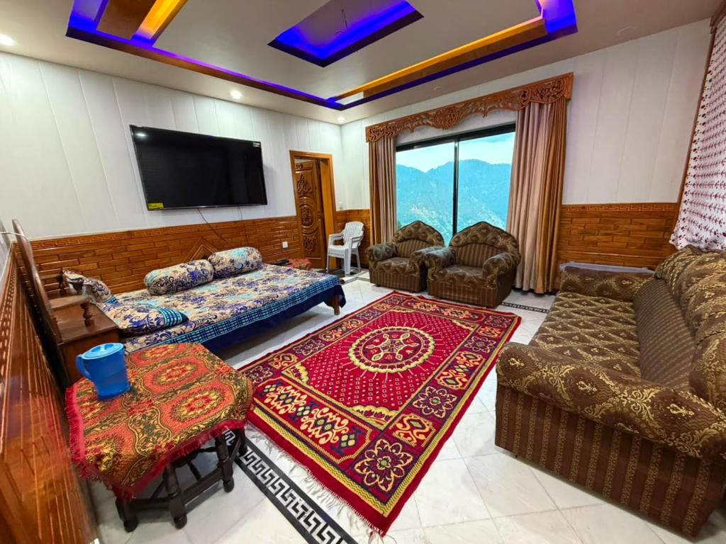 a living room with a couch and a tv at Galiyat Peak in Abbottabad