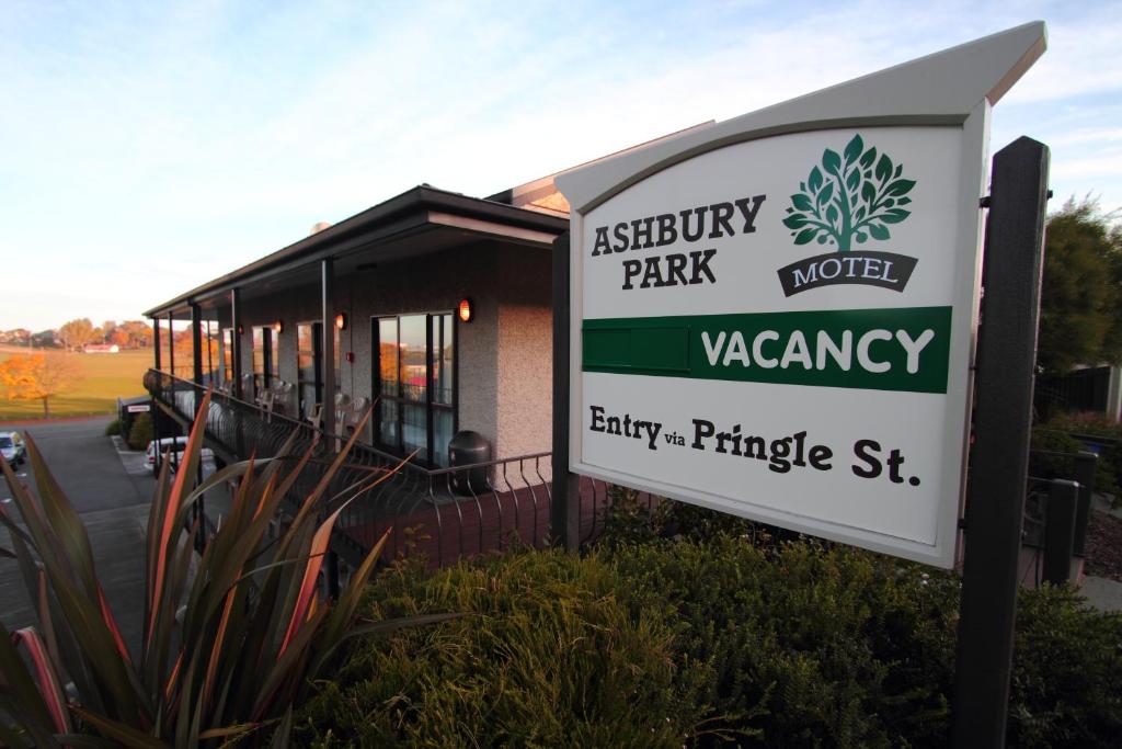 a sign in front of a building with a park vacancy sign at Ashbury Park Motel in Timaru
