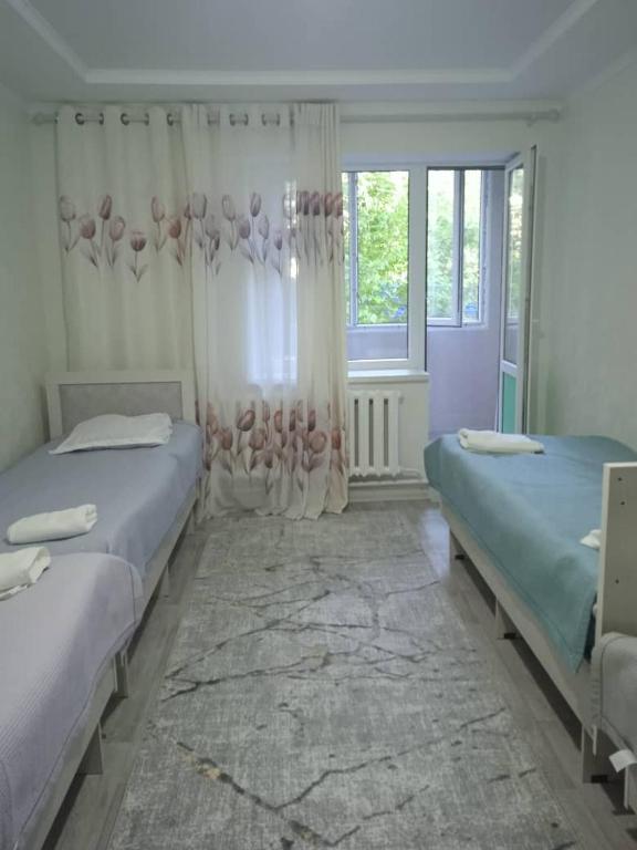 a bedroom with two beds and a window at Жаркын in Naryn
