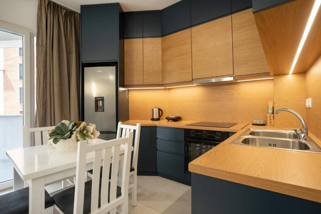 a kitchen with a sink and a table with a counter at MaisonNova Deluxe 2 in Tirana