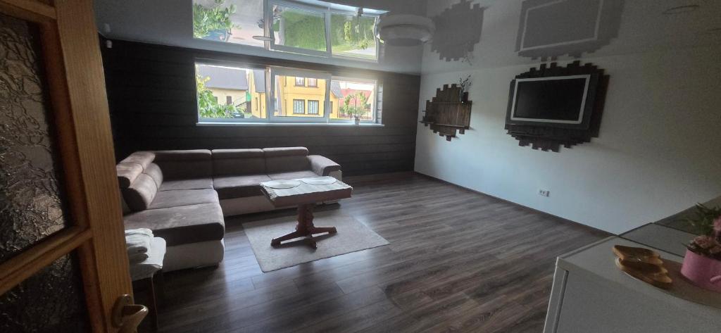 a living room with a couch and a tv at Pas Jolantą in Ignalina