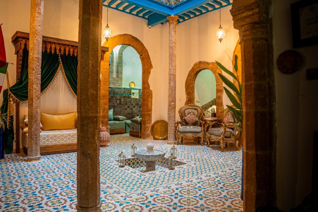 a living room with a couch and a table at Riad Le Cheval Blanc in Safi
