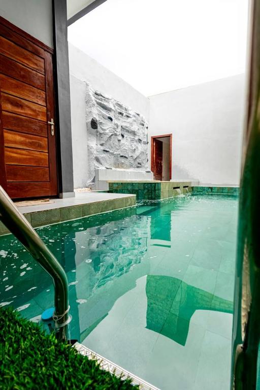 a swimming pool with blue water in a building at Luz RÉSIDENCE in Abomey-Calavi