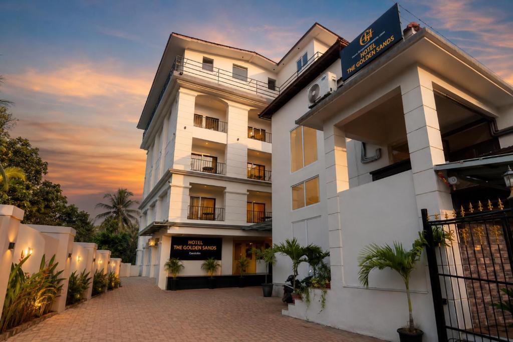 a white building with a sunset in the background at Hotel The Golden Sands, Located on Calangute Main Road in Calangute