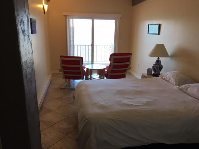 a bedroom with a bed and a table and chairs at The Inn on the Wharf in Lubec