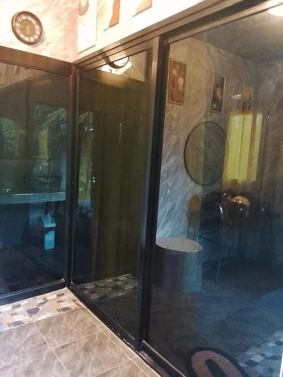a room with glass doors and a clock on the wall at Lhady Roxy in Siquijor