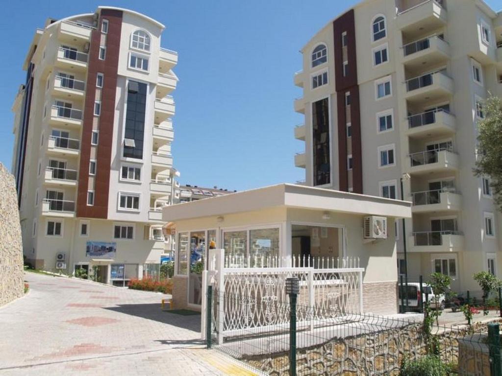 uma vista de dois edifícios de apartamentos com um portão em Orion Resort Gülay 18 em Avsallar