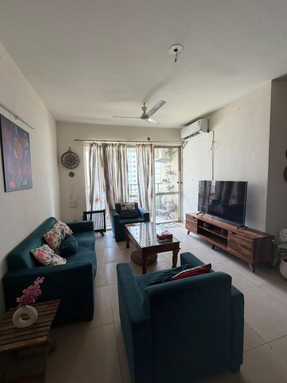 a living room with couches and a flat screen tv at Apartment for rent in Noida