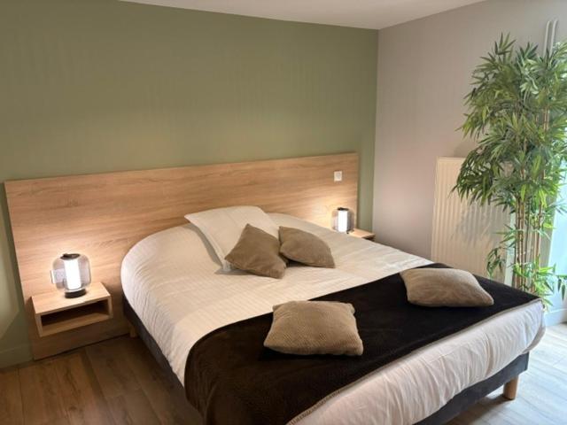 a bedroom with a large bed with two pillows on it at Le prélong in Murol