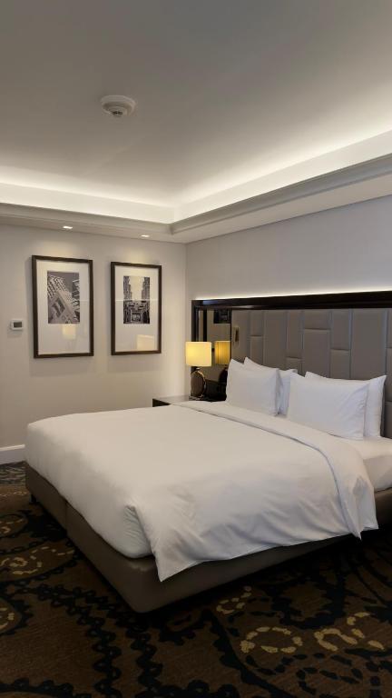 a large white bed in a hotel room at Ayushmaan Hotel - near Jabalpur Railway Station in Jabalpur