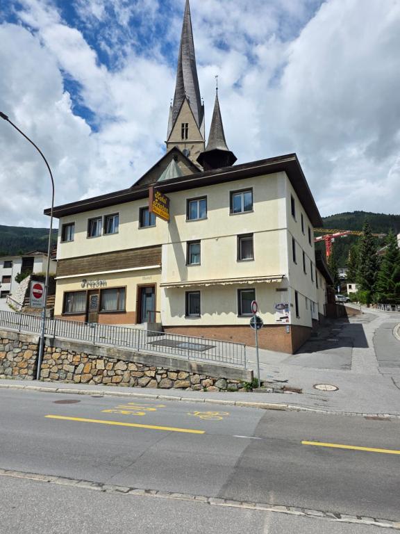 a large building with a church steeple on top of it at Hotel Frieden in Davos