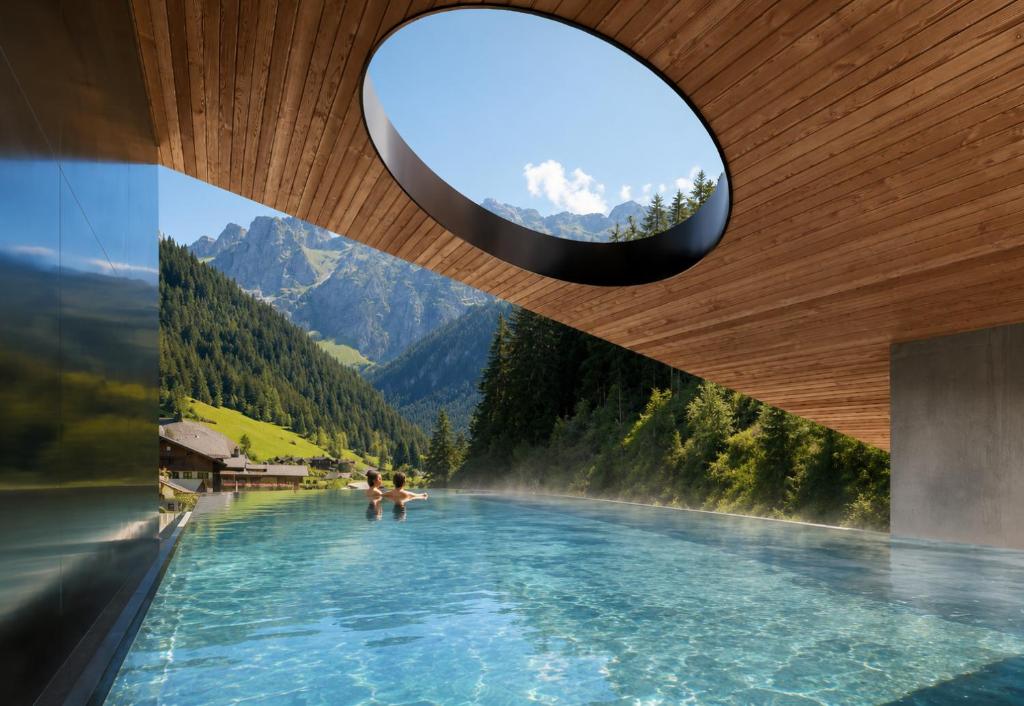 ein Infinity-Pool mit Blick auf einen Berg in der Unterkunft The Oswald Grand Hotel in Wolkenstein in Gröden
