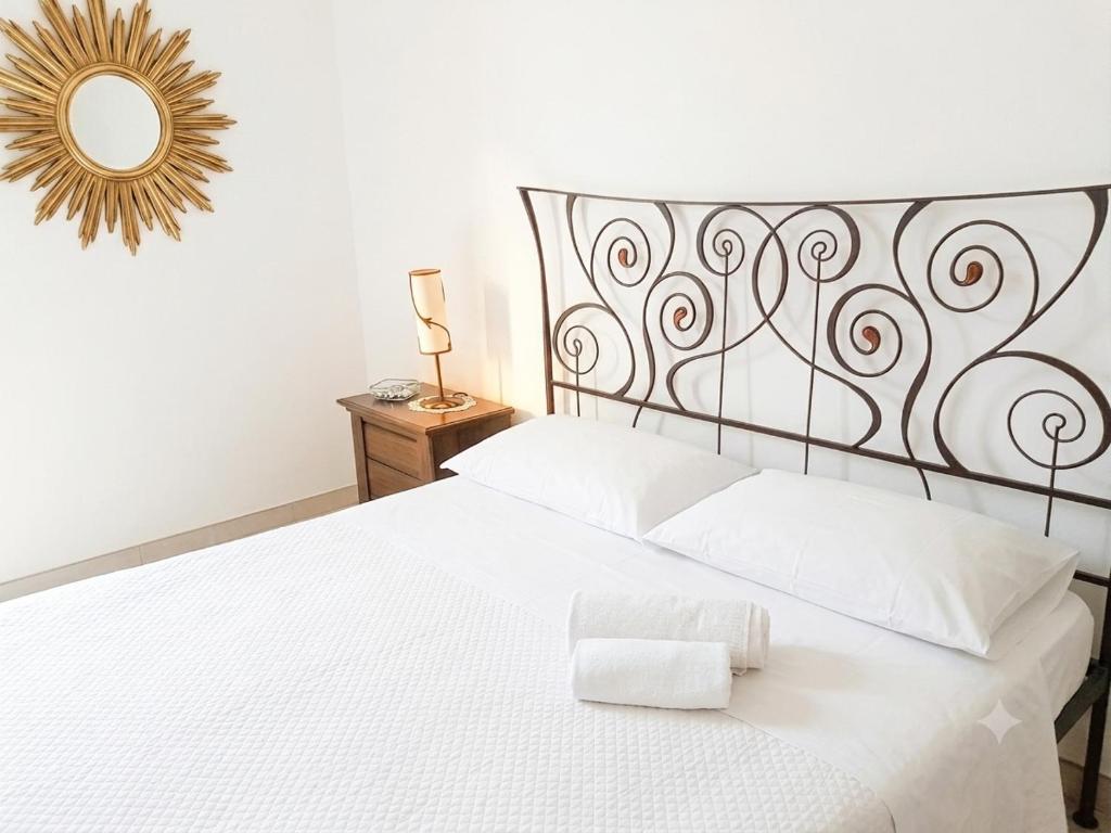 a bedroom with a white bed and a mirror at Andasì in Pachino